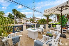 Huntington Beach house for rent - A patio with white furniture and a blue and white striped cushion.