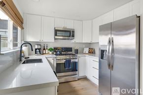 Huntington Beach house for rent - A modern kitchen with white cabinets and stainless steel appliances.
