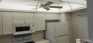 Fort Myers condo for rent - A kitchen with a white refrigerator and a white microwave oven.