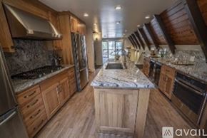 Truckee house for rent - A kitchen with wooden cabinets and a marble countertop.