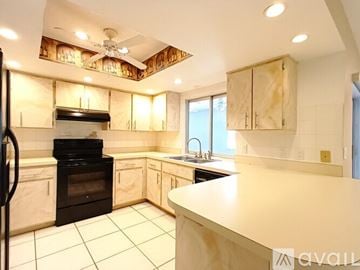 Cape Coral house for rent - A kitchen with a black oven and wooden cabinets.