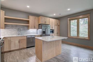 Eau Claire apartment for rent - A kitchen with wooden cabinets and a central island.