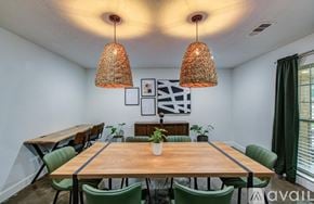 Houston house for rent - A dining room with a wooden table and green chairs.