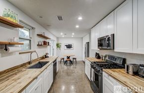 Houston house for rent - A kitchen with white cabinets and wooden countertops.