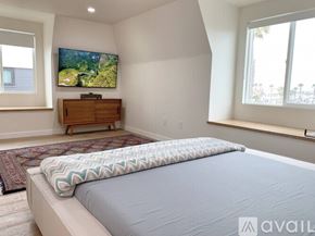 Huntington Beach apartment for rent - A bedroom with a large bed and a flat screen TV mounted on the wall.