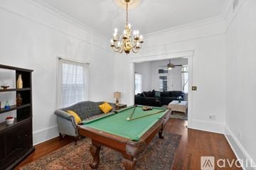 New Orleans house for rent - A living room with a red rug and a brown sofa.