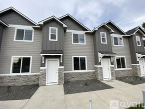 Caldwell apartment for rent - A row of houses with grey siding and white doors.