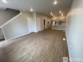 Caldwell apartment for rent - A spacious room with wooden flooring and a staircase on the left side.