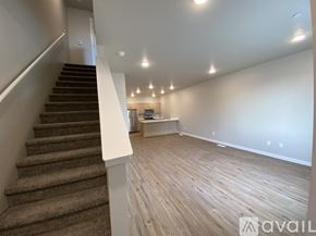 Caldwell apartment for rent - A spacious room with wooden flooring and a staircase leading to another level.