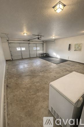 Columbus house for rent - A spacious garage with a white cabinet and a ceiling light.