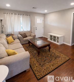 Columbus house for rent - A spacious living room with hardwood floors and a kitchen area in the background.