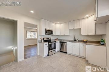 Colorado Springs house for rent - A kitchen with white cabinets and appliances is available for rent.