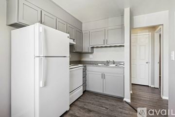 Colorado Springs apartment for rent - A white refrigerator is in a kitchen with white cabinets.