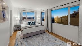 West Hollywood apartment for rent - A bedroom with a large bed and a view of the mountains outside the window.