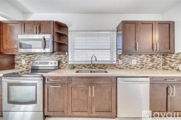 Miami house for rent - A kitchen with wooden cabinets and stainless steel appliances.