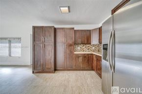 Miami house for rent - A kitchen with wooden cabinets and a stainless steel refrigerator.
