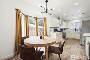 Desoto house for rent - A kitchen with a table and chairs in front of a window.