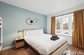 Desoto house for rent - A bedroom with a large bed, a nightstand with a lamp, and a mirror on the wall.