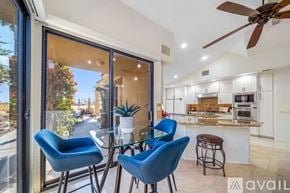La Quinta house for rent - A modern kitchen with blue chairs and a glass table.