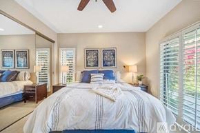 La Quinta house for rent - A bedroom with a large bed and a ceiling fan.