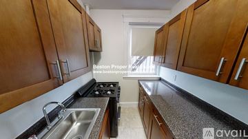 Boston apartment for rent - A kitchen with wooden cabinets and a stove top oven.