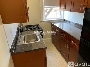 Boston apartment for rent - A kitchen with a stove top oven and sink.