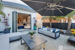 Huntington Beach house for rent - A patio with a table and chairs under an umbrella.