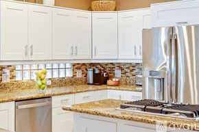Huntington Beach house for rent - A kitchen with a stainless steel refrigerator and a granite countertop.