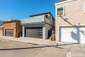 Huntington Beach house for rent - A two-story building with a garage door is situated between two other buildings.