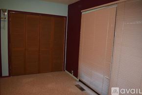 Susanville house for rent - A room with brown wooden closet doors and white blinds on the window.