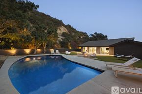 Los Angeles house for rent - A swimming pool in a backyard with a house and trees in the background.