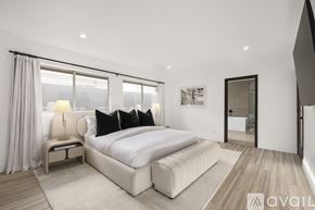 Los Angeles house for rent - A bedroom with a large bed and a window with curtains.