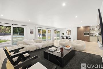 Los Angeles house for rent - A modern living room with a black coffee table and white furniture.