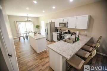 Kokomo house for rent - A kitchen with a white counter top and wooden floors.