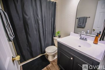 Kokomo house for rent - A kitchen with a black fridge and wooden cabinets.