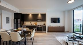 Miami apartment for rent - A modern dining room with a black table and white chairs.
