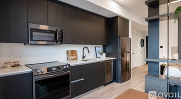 Miami apartment for rent - A modern kitchen with dark brown cabinets and stainless steel appliances.