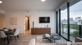 Miami apartment for rent - A modern living room with a view of the cityscape outside the large windows.