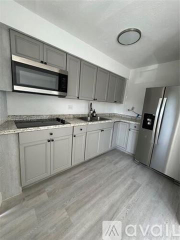 Miami apartment for rent - A kitchen with a refrigerator, microwave, and oven.