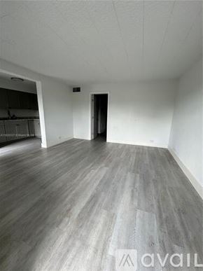Miami apartment for rent - A room with wooden flooring and a door on the right side.