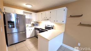 Miami apartment for rent - A kitchen with white cabinets and a stainless steel refrigerator.