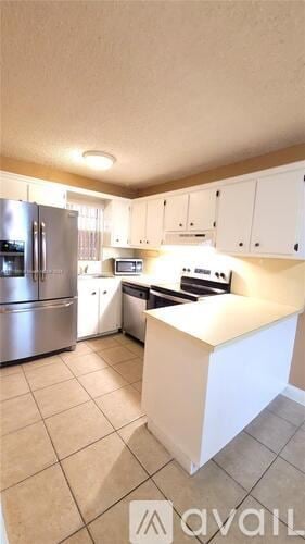 Miami apartment for rent - A kitchen with a white island in the middle.