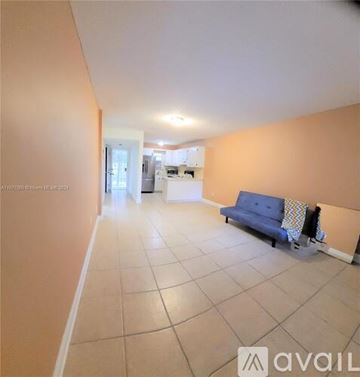 Miami apartment for rent - A living room with a blue sofa and a kitchen in the background.