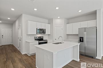 Jacksonville apartment for rent - A kitchen with white cabinets and a wooden floor.