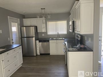 Orlando house for rent - A kitchen with white cabinets and a stainless steel refrigerator.