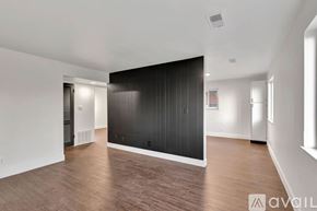 Highland Heights apartment for rent - A spacious room with wooden flooring and a large black wall.
