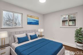 Highland Heights apartment for rent - A bedroom with a bed, two lamps, a potted plant, and pictures on the wall.