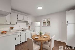 Highland Heights apartment for rent - A kitchen with white cabinets and a wooden table with chairs.