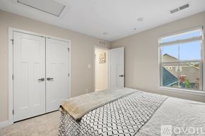 Frederick townhouse for rent - A bedroom with a bed, dresser, and mirror.