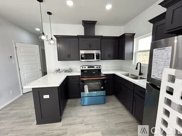 Alton apartment for rent - A modern kitchen with black cabinets and a white countertop.